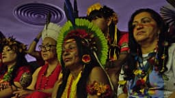 Mulheres indígenas de diferentes etnias reunidas em evento em Brasília, com cocares e pintura corporal