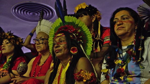 Mulheres indígenas de diferentes etnias reunidas em evento em Brasília, com cocares e pintura corporal