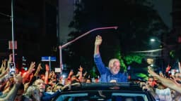 Lula acena para a multidão em carro aberto durante ato de vitória à noite
