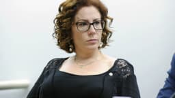 Retrato oficial de Carla Zambelli, com cabelo cacheado e óculos de grau