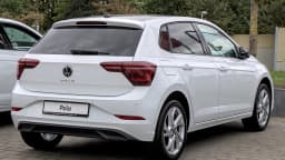 Volkswagen Polo branco visto de trás, estacionado em pátio