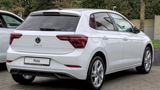 Volkswagen Polo branco visto de trás, estacionado em pátio