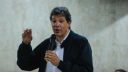 Fernando Haddad discursa segurando um microfone