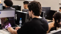 Jovens em laboratório de informática durante formação em cibersegurança