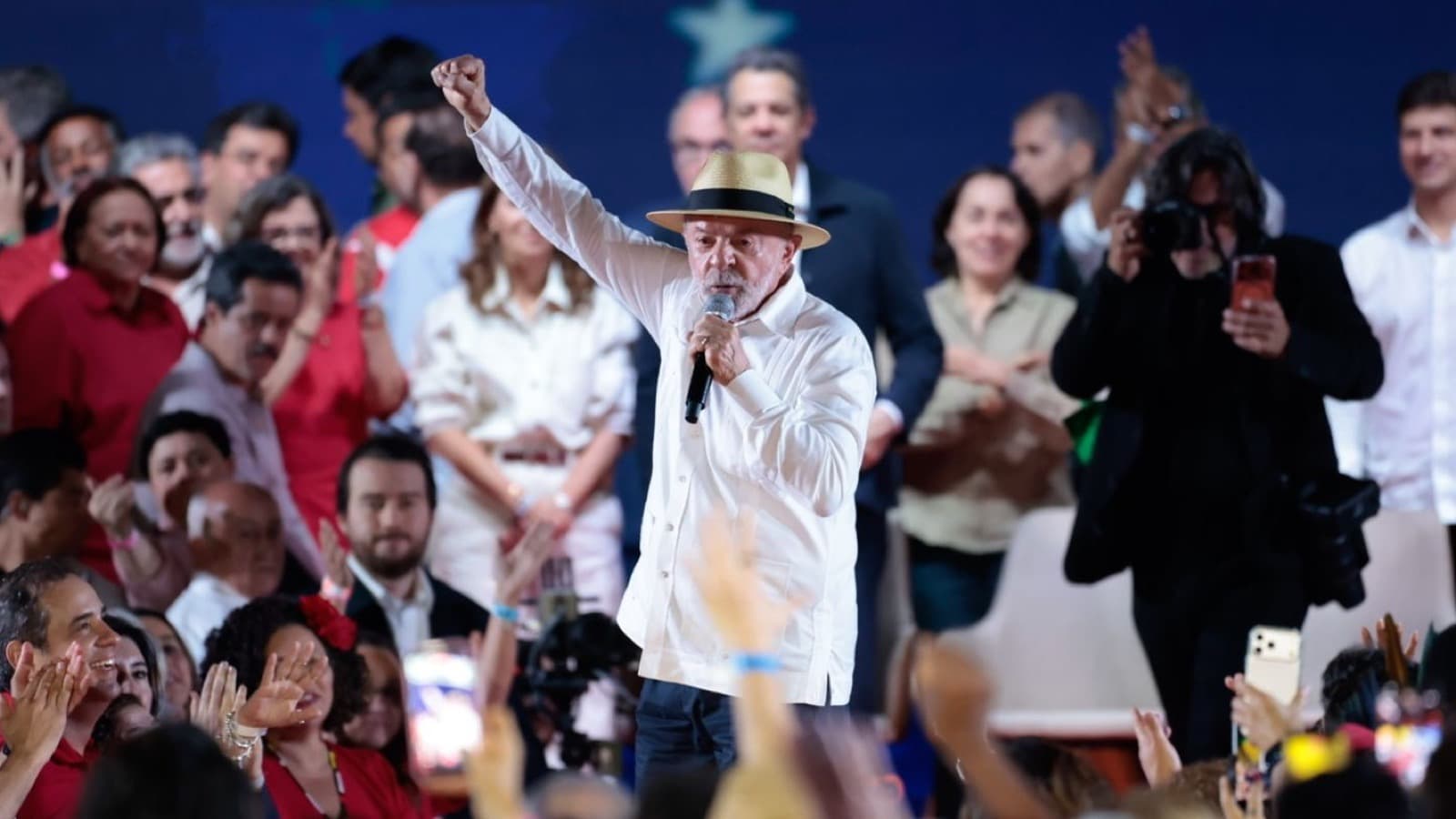 Lula discursa com o punho erguido durante a convenção do PT que oficializou sua candidatura à reeleição, cercado por apoiadores