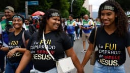 Mulheres evangélicas caminham em ato público usando camisetas com mensagens religiosas