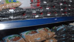 Pacotes de feijão empilhados em prateleira de mercado