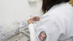 Profissional de saúde prepara dose de vacina em posto de vacinação contra o sarampo
