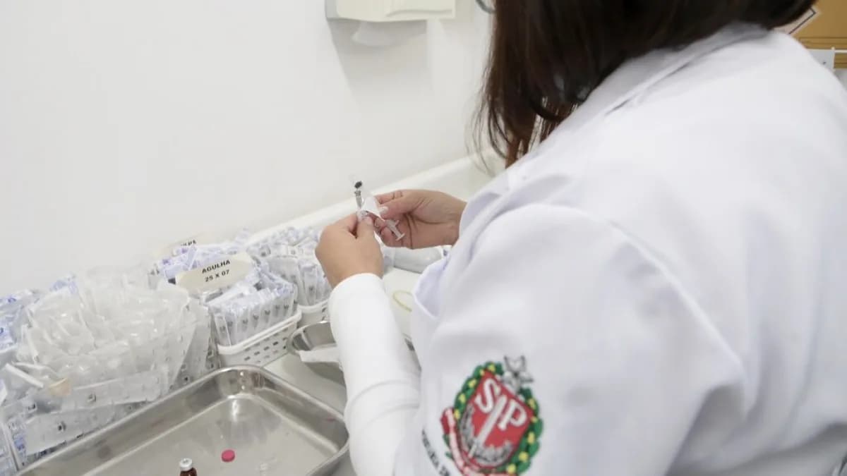 Profissional de saúde prepara dose de vacina em posto de vacinação contra o sarampo