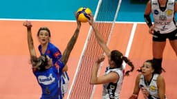 Jogadoras disputam bola no ataque em partida de vôlei