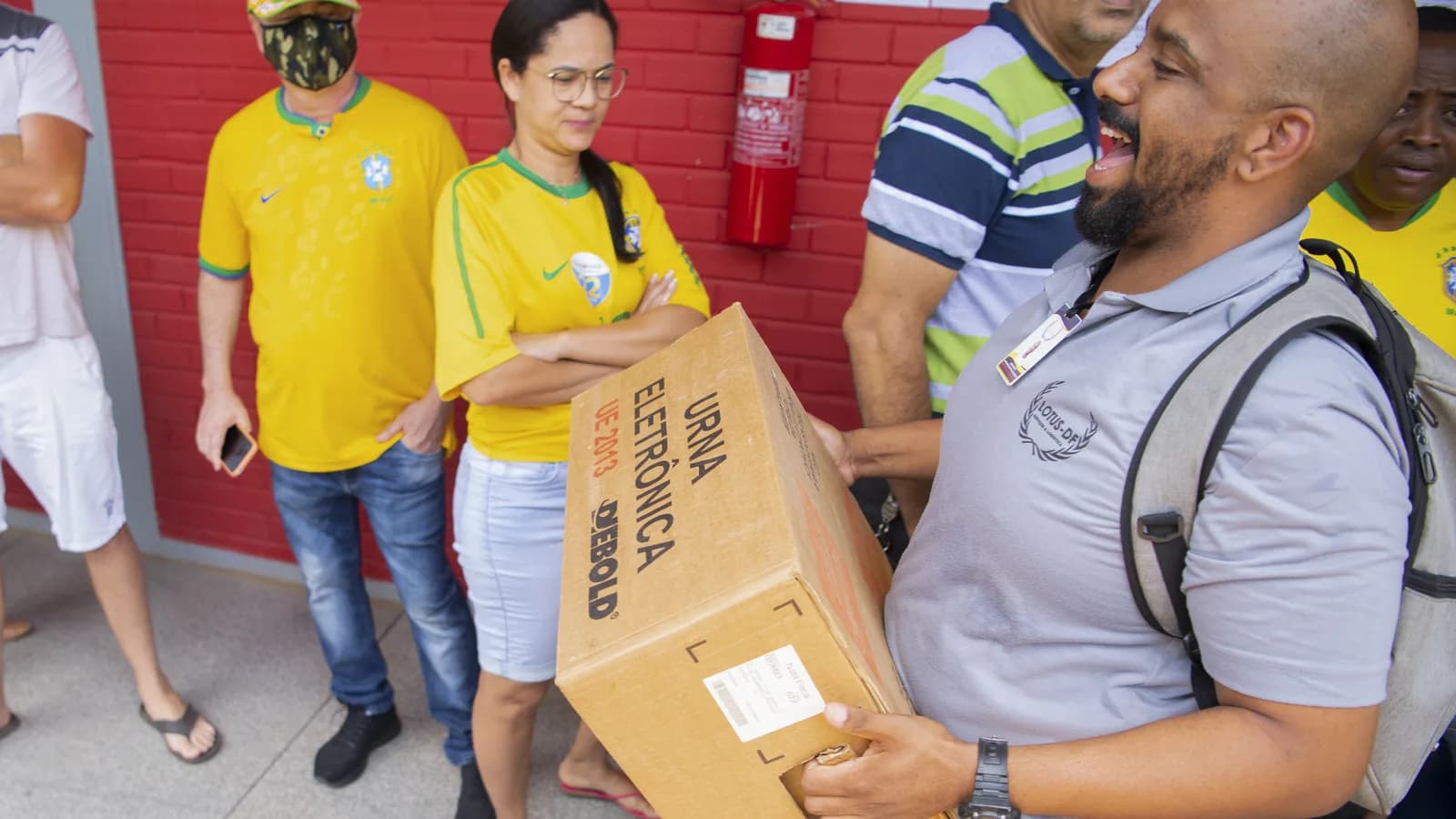 Mesários carregam urna eletrônica em dia de votação de segundo turno