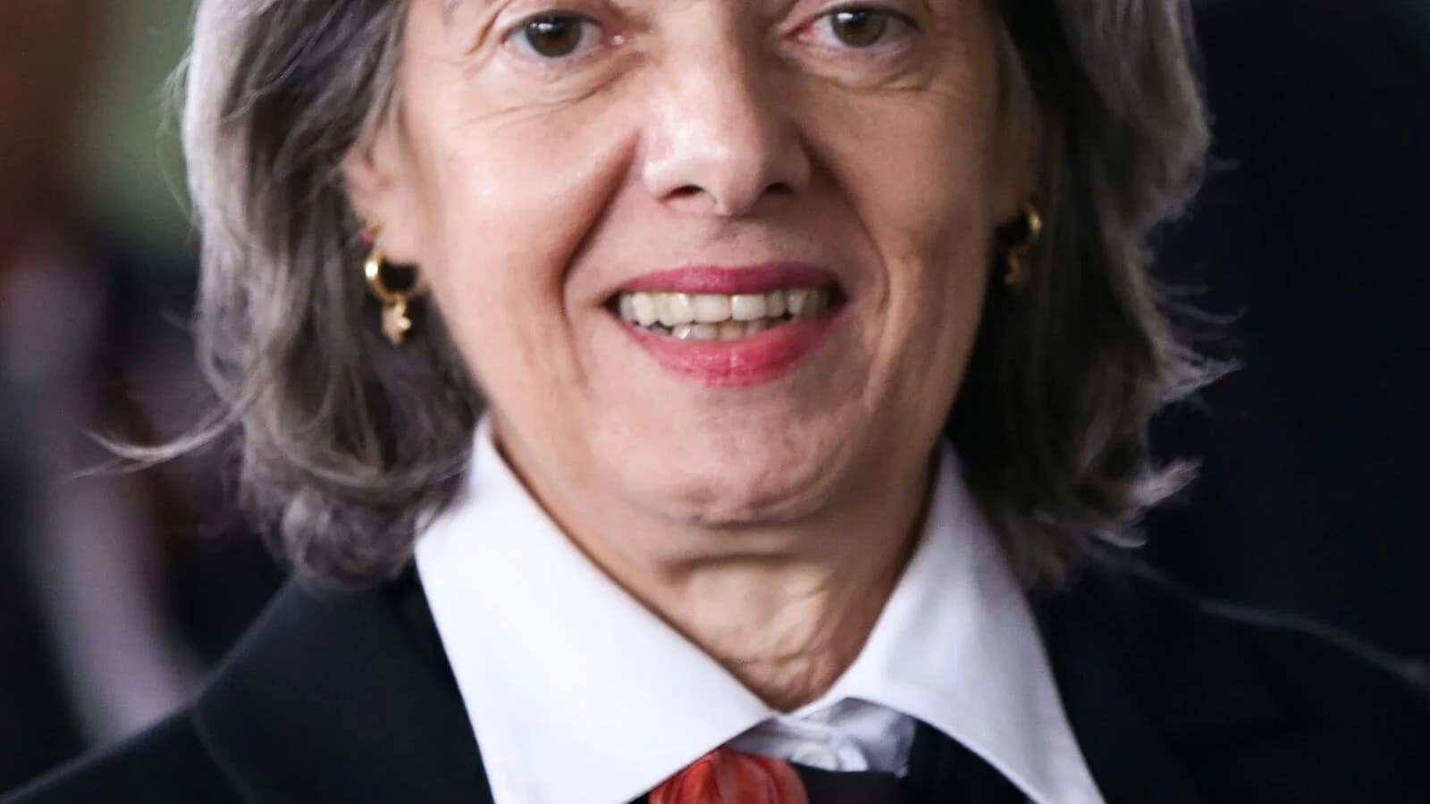 Cármen Lúcia, ministra do STF, sorri usando toga em evento institucional