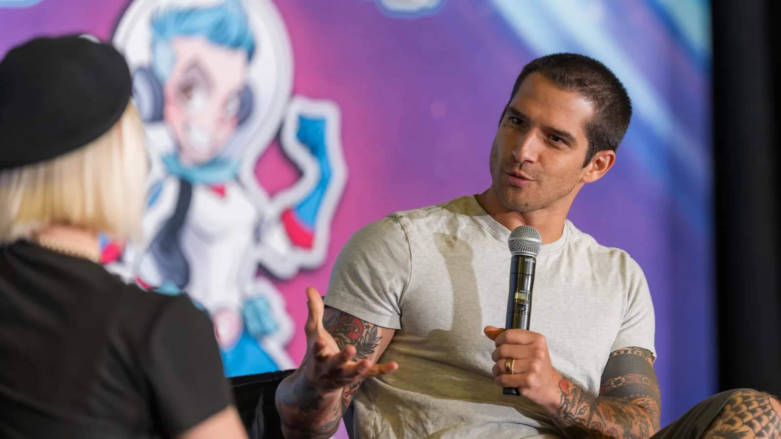 Tyler Posey em evento para fãs, com microfone na mão