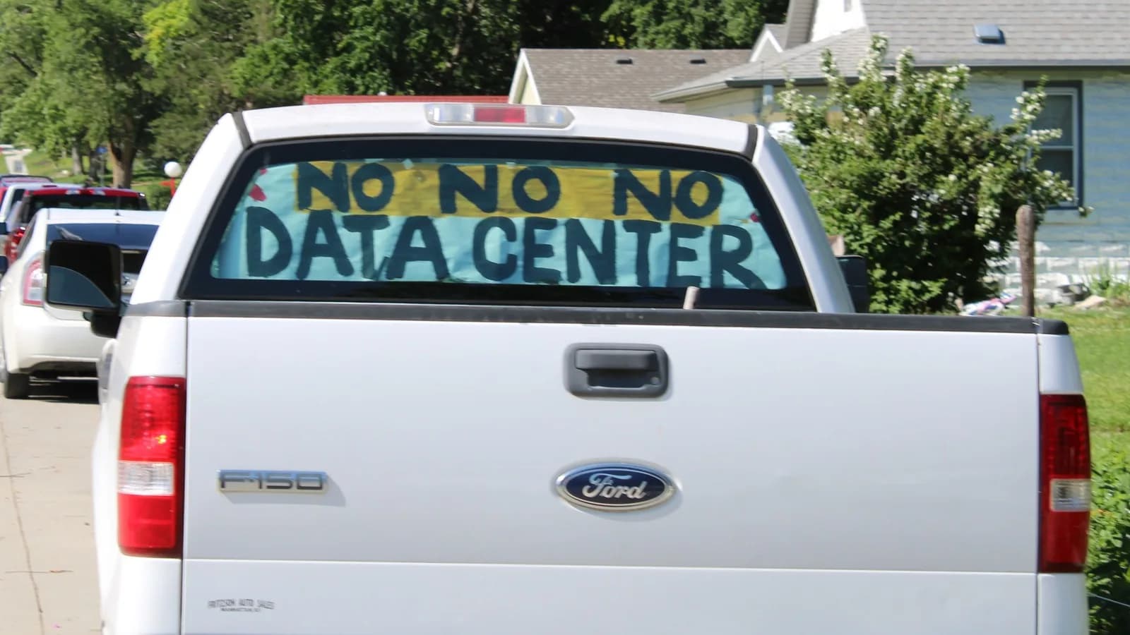 Caminhonete com cartaz pintado à mão nos vidros traseiros dizendo 'No, no, no data center', em protesto contra a instalação de um data center em bairro rural do Kansas, EUA