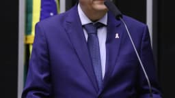 Deputado discursa na tribuna da Câmara usando laço rosa em homenagem à campanha Outubro Rosa