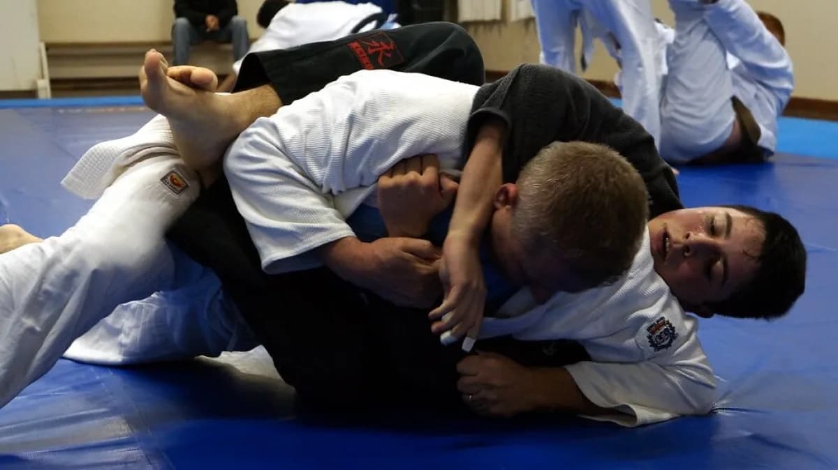 Dois praticantes de jiu-jítsu durante treino em tatame