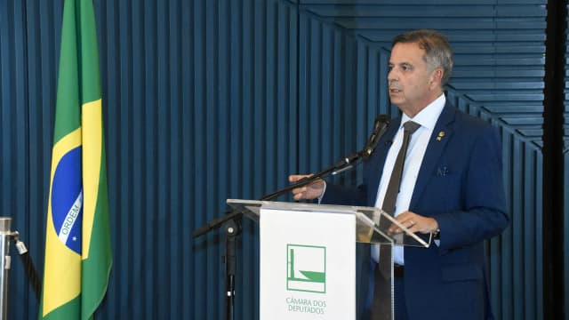 Rogério Marinho discursa em púlpito com a bandeira do Brasil ao fundo