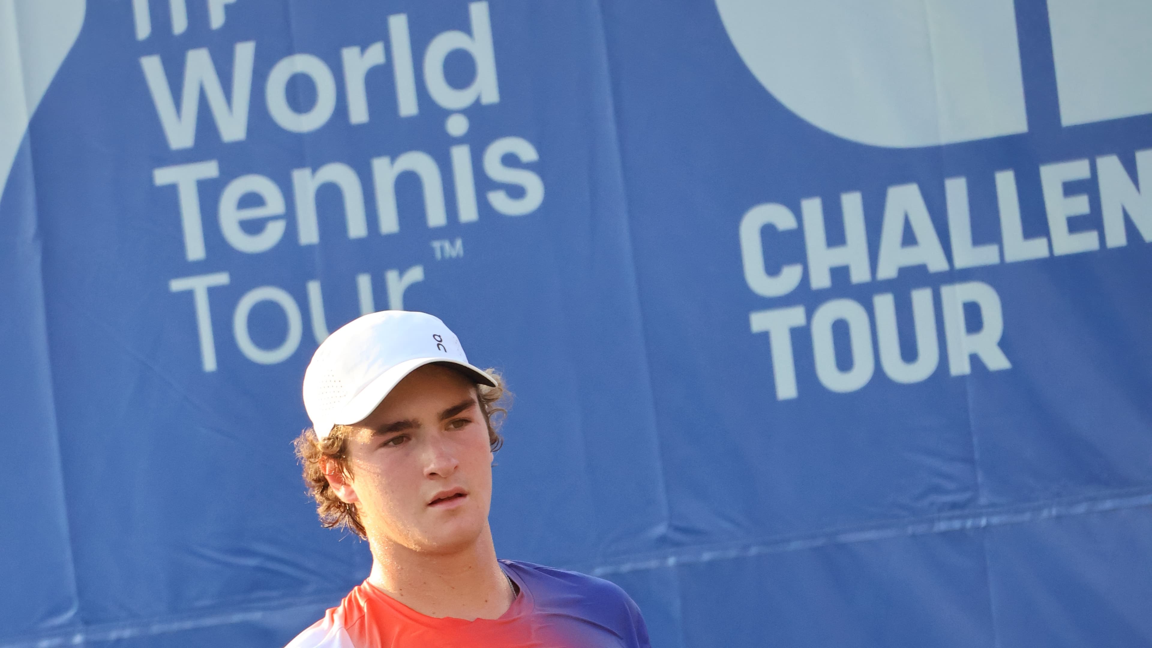 João Fonseca observa o lance durante partida de tênis, usando boné branco (foto de arquivo)