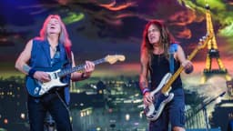 Integrantes do Iron Maiden tocando guitarra e baixo durante show