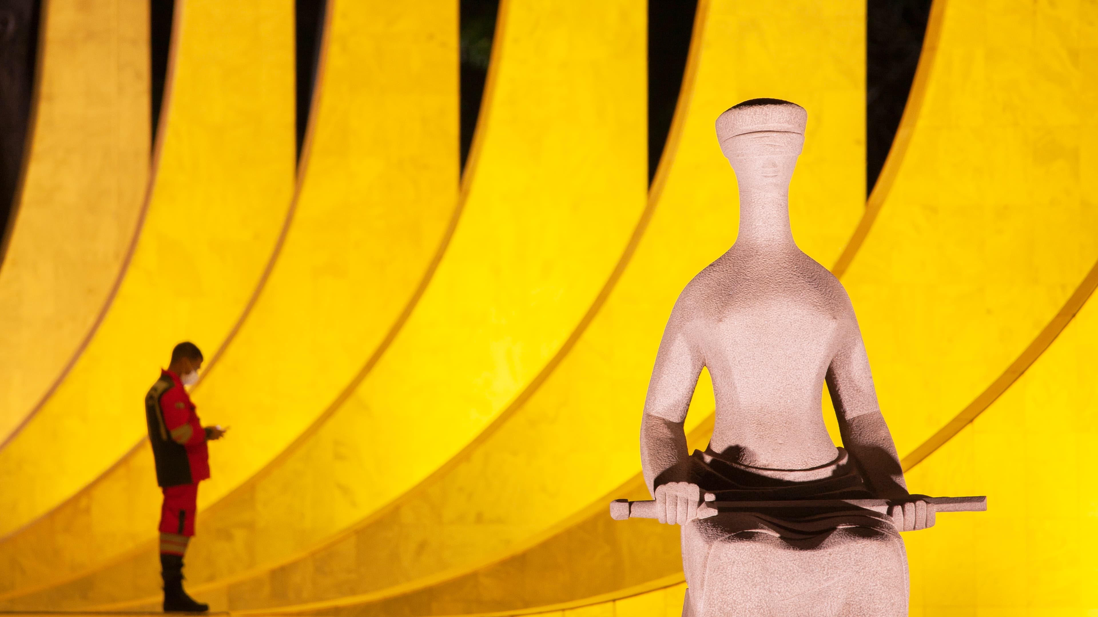 Estátua da Justiça em frente ao prédio do Supremo Tribunal Federal, em Brasília, iluminada à noite
