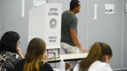 Eleitores votam em cabine da Justiça Eleitoral pouco antes do fim da votação