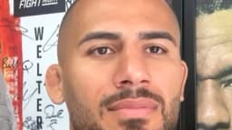 Vitor Petrino em entrevista em frente a pôster do UFC