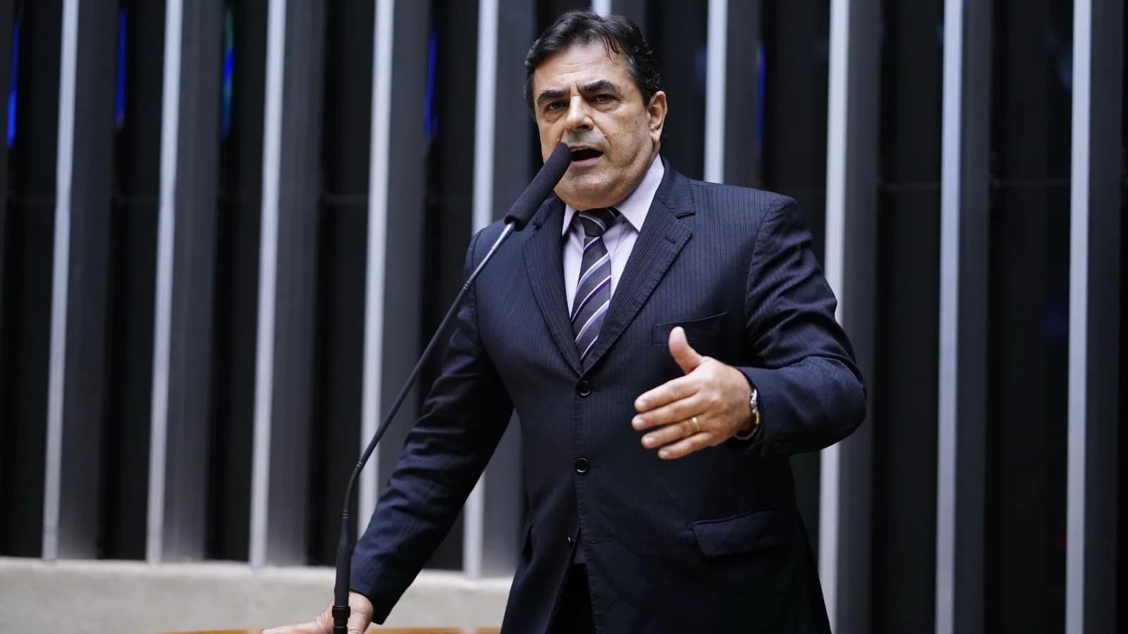 Domingos Sávio discursa na tribuna da Câmara dos Deputados, de terno escuro, diante do microfone