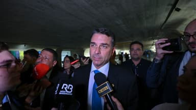Senador Flávio Bolsonaro concede entrevista cercado de microfones de emissoras no Senado