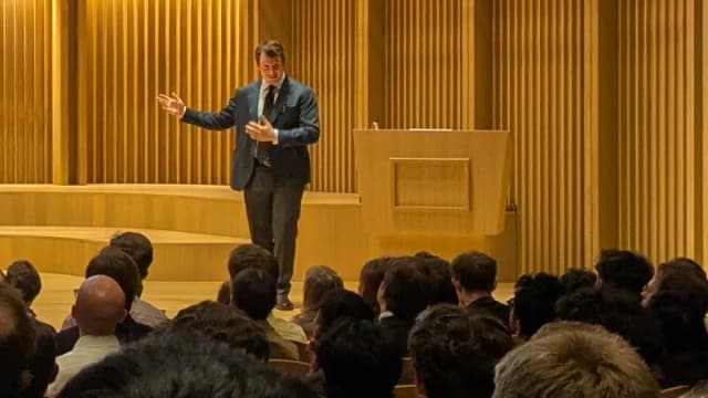 Jack Clark, cofundador da Anthropic, gesticula ao discursar em auditório lotado