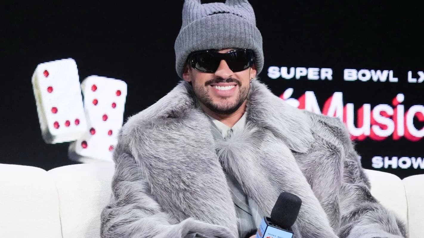 Bad Bunny sorri em coletiva de imprensa do Super Bowl LX Halftime Show, usando touca cinza e casaco de pelúcia