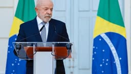 Presidente Luiz Inácio Lula da Silva discursa em púlpito com bandeiras do Brasil ao fundo