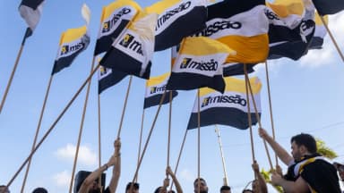 Militantes do partido Missão erguem bandeiras em ato de campanha de Renan Santos
