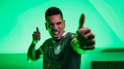 Paulinho comemora com as duas mãos erguidas, vestindo o uniforme do Palmeiras