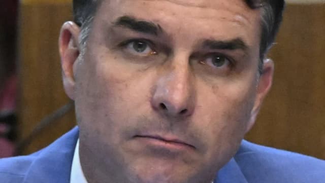 Flávio Bolsonaro com expressão séria no plenário do Senado Federal