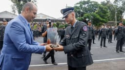 Oficial do Corpo de Bombeiros Militar de Minas Gerais recebe placa de autoridade civil durante cerimônia oficial