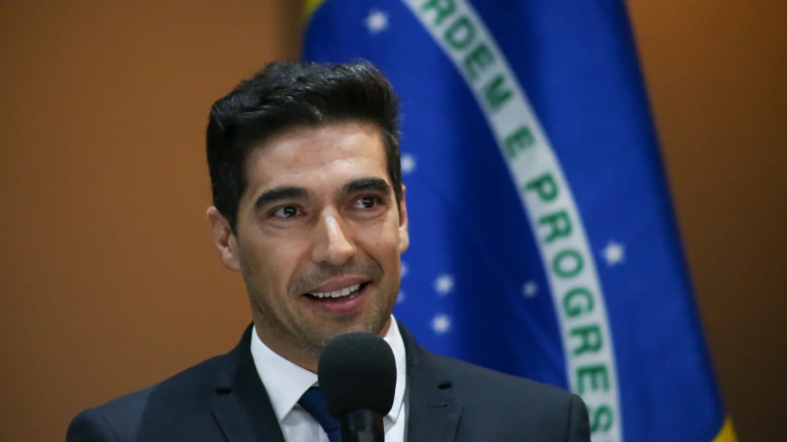 Abel Ferreira discursa em evento oficial, com bandeiras do Brasil e de São Paulo ao fundo