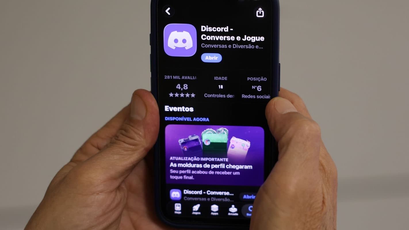 Mãos seguram smartphone com a página do aplicativo Discord aberta na loja de aplicativos