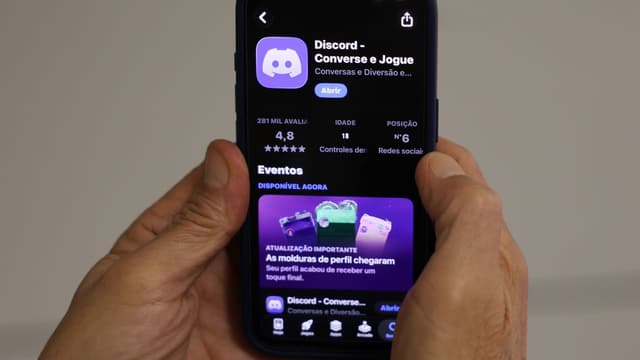 Mãos seguram smartphone com a página do aplicativo Discord aberta na loja de aplicativos