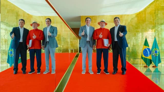 Lula, Hugo Motta e Davi Alcolumbre posam sorrindo e com o polegar para cima no Palácio da Alvorada