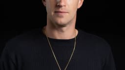 Retrato de Mark Zuckerberg, CEO da Meta, de blusa preta e colar dourado