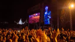 DJ se apresenta em telão de show para multidão com as mãos erguidas, foto de arquivo de outro festival