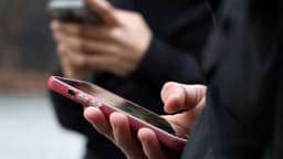 Close de mãos segurando smartphones, em referência ao uso de plataformas digitais por eleitores