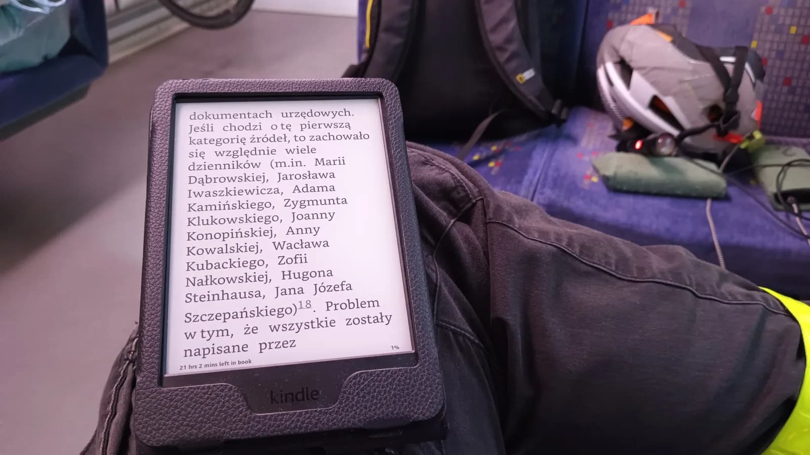 Pessoa segurando um Kindle durante uma viagem de transporte público