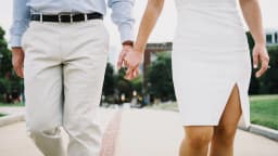 Casal caminha de mãos dadas