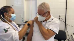 Profissional de saúde aplica dose de vacina em paciente