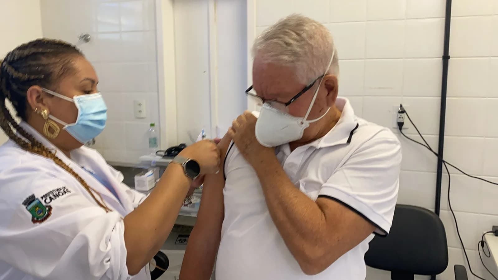 Profissional de saúde aplica dose de vacina em paciente