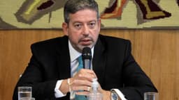 Arthur Lira, de terno escuro, fala ao microfone em evento institucional em Brasília