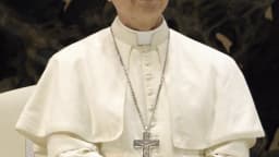 Papa Leão XIV em retrato oficial, vestido de branco, com crucifixo no peito