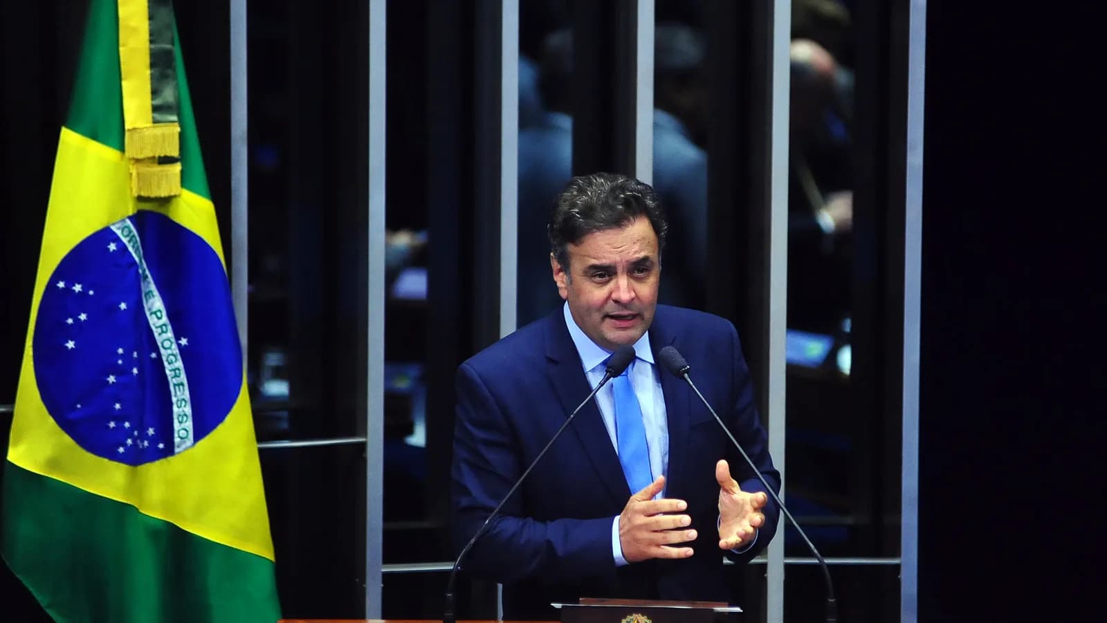 O senador e candidato Aécio Neves discursa em plenário, diante da bandeira do Brasil