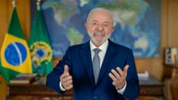 O presidente Luiz Inácio Lula da Silva, de terno azul, gesticula ao falar diante das bandeiras do Brasil e da Presidência da República, em foto de arquivo de novembro de 2025